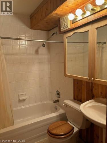 Bathroom featuring a tiled shower/tub combination, wood plank ceiling details, and a wall-mounted vanity with a light fixture - 30 Summit Avenue Unit# 604, Hamilton, ON - Indoor Photo Showing Bathroom