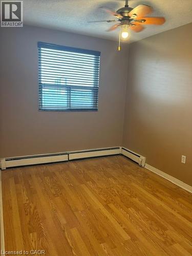 Room featuring wood-finish flooring, a ceiling fan with integrated lighting, and baseboard heating - 30 Summit Avenue Unit# 604, Hamilton, ON - Indoor Photo Showing Other Room