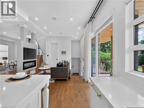 Kitchen area featuring white countertops, gold-tone hardware, and a window overlooking exterior greenery - 5178 Hunter Drive, Burlington, ON - Indoor