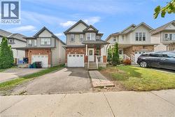 Two-story residence featuring a brick and siding exterior, an integrated single-car garage, and a paved driveway - 