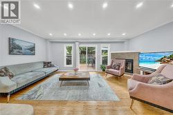 Spacious living area featuring wood-finish flooring, recessed lighting, and crown molding - 