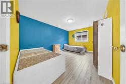 Interior room featuring painted walls, wood-finish flooring, and a window with horizontal blinds - 