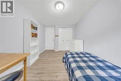 Room featuring light wood-finish flooring, light gray wall paint, and white trim - 