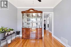 Hardwood flooring extending throughout, complemented by crown molding and light gray wall tones - 