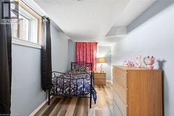 Room featuring wood-finish flooring, light blue walls, and a recessed window with white trim - 