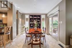 Custom built in cabinets, crown molding, built-in shelving, recessed lighting, and sliding glass doors opening to covered deck - 