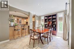 Dining area featuring tile flooring, built-in shelving, recessed lighting, and crown molding - 