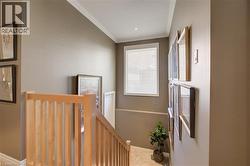 Wood-finish staircase with natural wood balusters, step lighting. - 