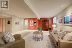 Spacious lower-level area with recessed lighting, neutral carpeting, half tone designer painting - 