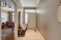 Entryway featuring tiled flooring, crown molding, and a transom window above the front door - 