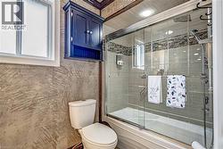 Bathroom featuring a combination bathtub and shower with glass enclosure - 