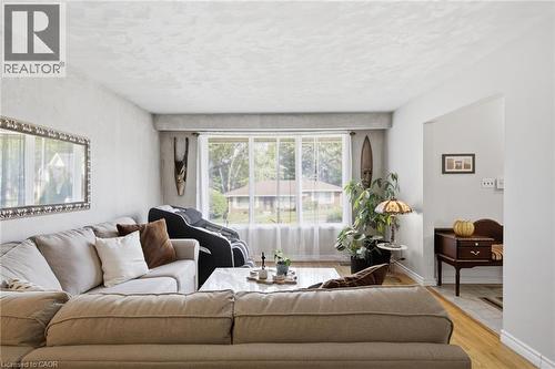Living area featuring a large picture window, light wood-finish flooring, and a cased opening - 11 Summit Crescent, Guelph, ON - Indoor Photo Showing Living Room