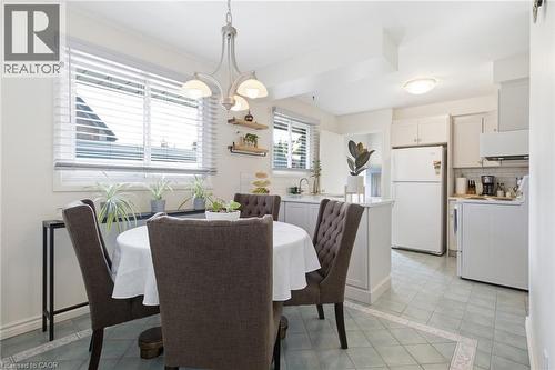 Kitchen and dining area featuring light-toned cabinetry, light-colored tile flooring, and multiple windows - 11 Summit Crescent, Guelph, ON - Indoor Photo Showing Dining Room