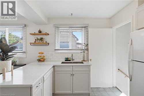 Kitchen featuring light gray cabinetry, white countertops, subway tile backsplash, and a stainless steel sink with a gooseneck faucet - 11 Summit Crescent, Guelph, ON - Indoor Photo Showing Kitchen