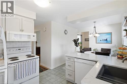 Kitchen featuring white cabinetry, white subway tile backsplash, white appliances, and light-toned countertops - 11 Summit Crescent, Guelph, ON - Indoor Photo Showing Kitchen