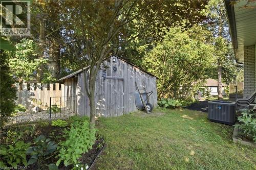 Expansive backyard featuring a mature wood-paneled storage shed, manicured lawn - 11 Summit Crescent, Guelph, ON - Outdoor