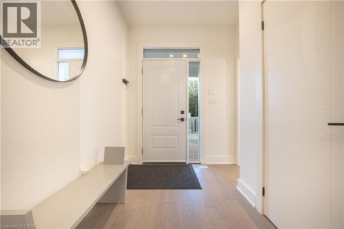 Entryway featuring a white paneled door with transom window, light wood-finish flooring, and a modern white door with horizontal detailing - 9 Princeton Common, St. Catharines, ON - Indoor Photo Showing Other Room