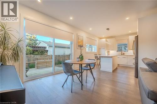 Open-concept living area featuring wood-finish flooring, recessed lighting, and a modern kitchen with white cabinetry and an island - 9 Princeton Common, St. Catharines, ON - Indoor