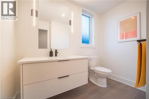 Modern bathroom featuring a floating vanity with a white countertop and integrated sink, matte black faucet, and a large wall-mounted mirror - 9 Princeton Common, St. Catharines, ON - Indoor Photo Showing Bathroom