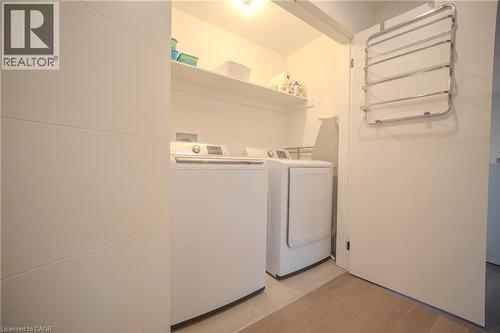 Dedicated laundry space featuring a white washer and dryer pair, recessed shelving, and tiled flooring - 9 Princeton Common, St. Catharines, ON - Indoor Photo Showing Laundry Room