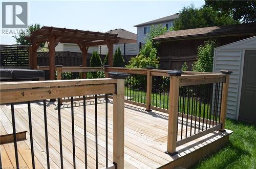 Spacious outdoor deck featuring natural wood decking, sturdy wood railings with black balusters, and a built-in pergola - 275 Locheed Drive Unit# Lower, Hamilton, ON - Outdoor With Exterior