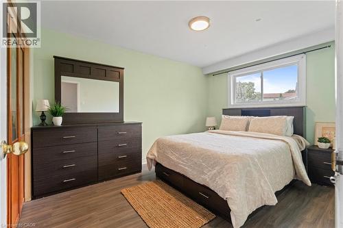 Spacious room featuring wood-finish flooring, a contemporary ceiling light fixture, and a large window providing natural illumination - 383 Bartley Bull Parkway, Brampton, ON - Indoor Photo Showing Bedroom