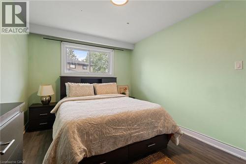 Bedroom featuring light green walls, wood-finish flooring, and a white window frame - 383 Bartley Bull Parkway, Brampton, ON - Indoor Photo Showing Bedroom