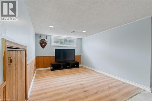 Interior space featuring wood-finish flooring, light blue walls with a wood panel wainscoting, recessed lighting, and a white ceiling - 383 Bartley Bull Parkway, Brampton, ON - Indoor Photo Showing Other Room