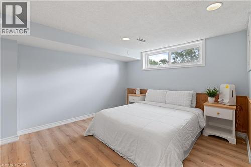 Bedroom featuring wood-finish flooring, light blue walls, and a white trim baseboard - 383 Bartley Bull Parkway, Brampton, ON - Indoor Photo Showing Bedroom
