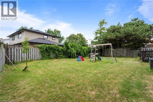 Expansive backyard featuring a large grass lawn, mature perimeter trees, and wood fencing - 383 Bartley Bull Parkway, Brampton, ON - Outdoor With Backyard