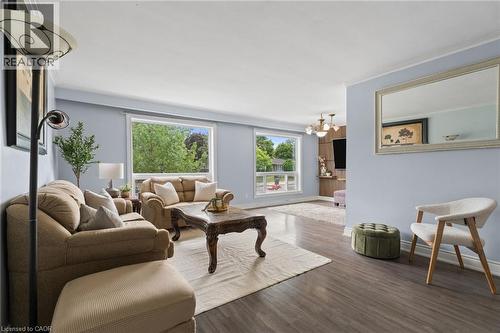 Living area featuring dark wood-finish flooring, light blue walls, and white crown molding - 383 Bartley Bull Parkway, Brampton, ON - Indoor Photo Showing Living Room