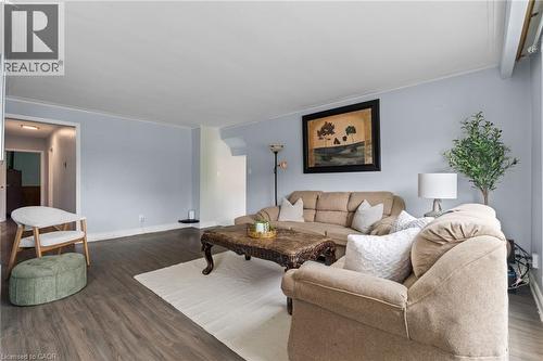 Spacious living area featuring wood-finish flooring, light blue wall paint, and white trim molding - 383 Bartley Bull Parkway, Brampton, ON - Indoor Photo Showing Living Room