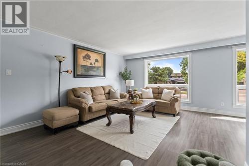 Spacious living area featuring wood-finish flooring, light blue walls, and white trim - 383 Bartley Bull Parkway, Brampton, ON - Indoor Photo Showing Living Room