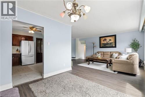 Spacious living area featuring wood-finish flooring, light blue walls, and white crown molding - 383 Bartley Bull Parkway, Brampton, ON - Indoor