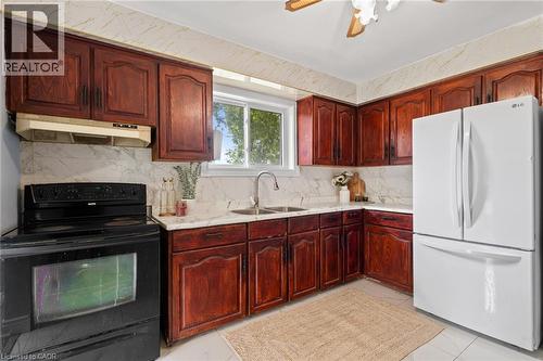 Kitchen featuring rich wood cabinetry, white countertops, and a white refrigerator - 383 Bartley Bull Parkway, Brampton, ON - Indoor Photo Showing Kitchen With Double Sink