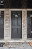 Dark paneled entry door framed by light-colored brick facade - 