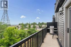 Outdoor balcony featuring concrete flooring, a black metal railing, and a privacy wall - 