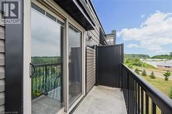 Private balcony featuring a sliding glass door, concrete flooring, and black metal railings - 