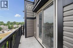 Private balcony featuring a concrete surface, black metal railing, and sliding glass door - 