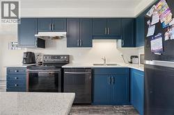 Kitchen featuring blue shaker-style cabinetry with brushed nickel hardware, white countertops, and wood-finish flooring - 