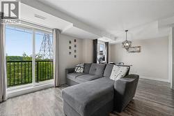 Living area with wood-finish flooring and a geometric pendant light fixture - 