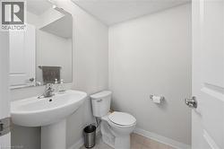 Pedestal sink with chrome faucet, large wall-mounted mirror, and tile flooring - 