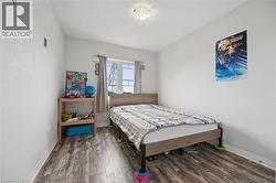 Bedroom featuring wood-finish flooring, a double window, and a flush-mount ceiling light - 