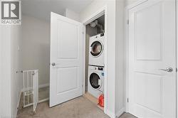 Dedicated laundry closet featuring a stacked washer and dryer unit - 