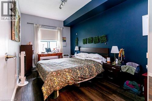 Bedroom featuring wood-finish flooring, a prominent window, a built-in recessed ceiling light, and a two-tone wall treatment - 175 Hunter Street E Unit# 103, Hamilton, ON - Indoor Photo Showing Bedroom