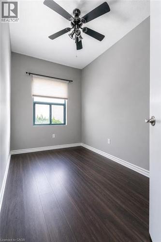 Room featuring dark wood-finish flooring, light grey painted walls, and white baseboards - 175 Hunter Street E Unit# 103, Hamilton, ON - Indoor Photo Showing Other Room