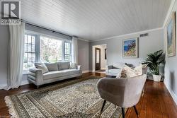 Bright interior space featuring a multi-pane bay window, wood-finish flooring, and a paneled ceiling - 