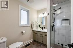 Bathroom featuring a glass-enclosed shower with subway tile surround, matte black fixtures, and an integrated niche - 