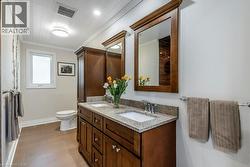 Double vanity with undermount sinks, granite countertop, and wood-finish cabinetry - 