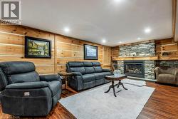Wood-finish flooring with a stone-clad fireplace and wood mantel - 
